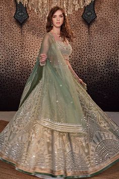 Jade green lehenga with mirror, thread, pearl and bead embroidery and attached cancan. Paired with a pearl and stone embroidered padded blouse with tasseled hem and embroidered organza dupatta.
Components: 3
Pattern: Embroidered
Type Of Work: Hand and Machine
Neckline: Sweetheart
Sleeve Type: Sleeveless
Fabric: Organza
Color: Green
Other Details: 
Model Height: 5ft 8inches, wearing size XS
Lehenga length: 44 inches
Occasion: Wedding - Aza Fashions Elegant Green Lehenga With Mirror Work, Elegant Pista Green Lehenga For Festive Occasions, Green Lehenga With Cutdana And Kundan, Green Lehenga With Mirror Work For Reception, Green Mirror Work Dupatta For Reception, Green Dupatta With Mirror Work For Reception, Green Lehenga For Navratri, Green Kundan Lehenga For Navratri, Designer Green Lehenga With Mirror Work