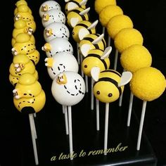 there are many yellow and white cake pops with bees on them