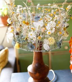 a wooden vase with flowers in it on a table