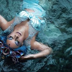 a woman with blue hair is floating in the water