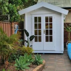 a small white shed sitting next to a pool