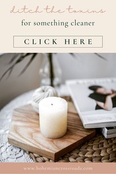 a white candle sitting on top of a wooden tray next to a book and plant