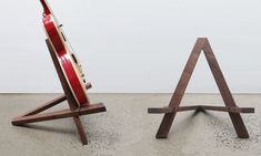 two wooden easels sitting next to each other on the floor in front of a white wall