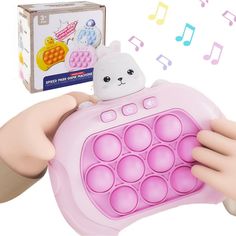 a person holding up a pink toy with music notes coming out of the box behind it