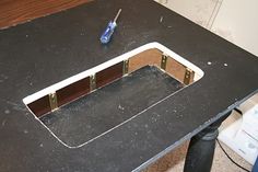 a black table with a hole in the middle and a blue toothbrush on top