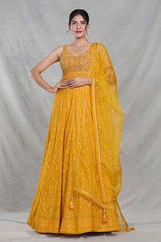 Mango yellow sleeveless full length gown with Mughal bloom embroidery using thread, sequin, beads and cutdana highlights. Paired with a ditsy sequin floret work dupatta. - Aza Fashions Traditional Yellow Sleeveless Anarkali Set, Yellow Sleeveless Dresses For Reception, Yellow Anarkali Set With Chikankari Embroidery For Reception, Yellow Dori Work Dress For Reception, Yellow Dress With Dori Work For Reception, Yellow Gown With Dupatta For Reception, Yellow Chikankari Embroidered Floor-length Lehenga, Yellow Gown With Intricate Embroidery For Festive Occasions, Festive Yellow Gown With Intricate Embroidery