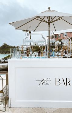 the bar is set up with an umbrella over it for guests to sit and drink