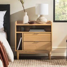 a nightstand with two drawers and a lamp next to it