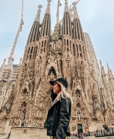 a woman standing in front of a very tall building