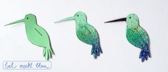 three green birds with blue speckles on them