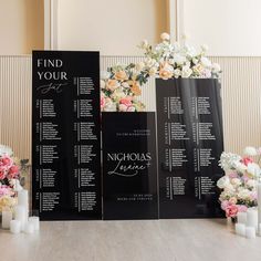 wedding seating chart with flowers and candles on the floor in front of wall decor for reception