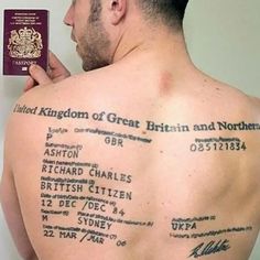 a man with tattoos on his back holding a passport