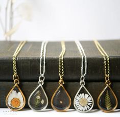 "Our Large Teardrop frame is a stunning classic and available in a variety of real preserved botanicals. Choose from a 24k gold or .999 sterling silver plated finish.  Baby's Breath is a symbol of purity of heart Daisy is a symbol of hope The Mustard Seed is a symbol of faith The Fern is a symbol of sincerity Pendant hangs from a gold or silver plated chain, plain or satellite, and available in 26\" or 30\" lengths. Model is wearing a 26\" chain. Materials are tarnish resistant. However, please Dainty Teardrop Nickel-free Necklace, Nature-inspired Teardrop Pendant Jewelry For Gifts, Nature-inspired Teardrop Pendant Jewelry Gift, Nature-inspired Gold Teardrop Jewelry, Gold Sterling Silver Necklaces With Pressed Flowers, Gold Sterling Silver Necklace With Pressed Flowers, Nickel-free Gold Botanical Jewelry, Nickel Free Gold Botanical Jewelry, Gold Teardrop Charm Necklaces For Jewelry Making