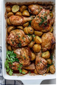 chicken, potatoes and parsley in a white casserole dish