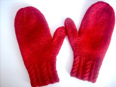 two red mittens sitting on top of a white table