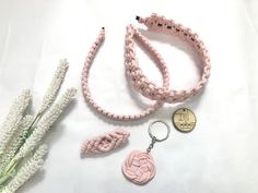 pink bracelets, keychain and flower on white background