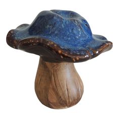 a blue ceramic mushroom sitting on top of a wooden base