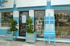 two blue chairs sitting in front of a store