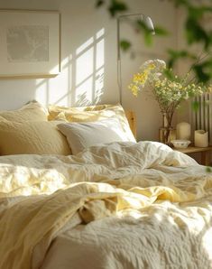 an unmade bed with white sheets and yellow linens in front of a window