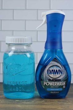 a bottle of detergent next to a jar of power wash on a wooden table