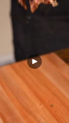 a wooden table with a video player on it's left hand and a black bag in the background