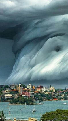 a very large cloud is in the sky over some water