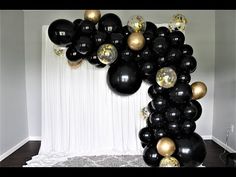 black and gold balloons are hanging from the ceiling