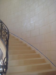 the stairs are painted white and have blue tape on each handrail, along with an iron railing