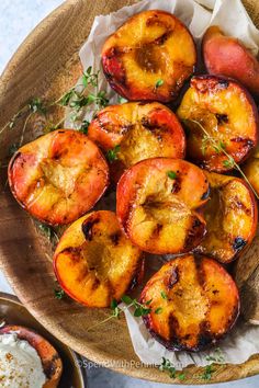 grilled peaches with yogurt and herbs on a wooden platter, ready to be eaten