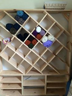 a wooden shelf filled with yarn and crochet hooks on it's sides