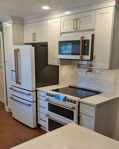 a kitchen with an oven, stove and refrigerator in it's center island area