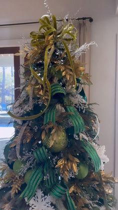 a christmas tree decorated with green and gold ornaments