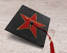 a black graduation cap with a red star on it