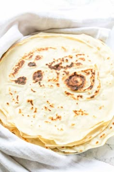 a stack of tortillas sitting on top of a white cloth