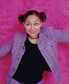 a woman in black shirt and purple jacket posing for the camera with her hands on her hips