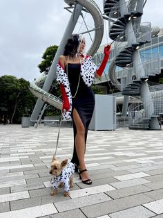 a woman is walking her small dog on a leash in front of a spiral staircase