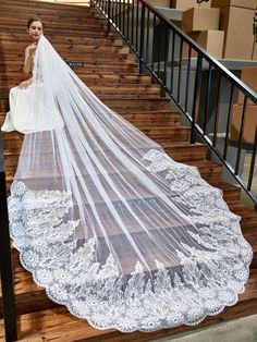 a woman is standing on some stairs wearing a wedding veil