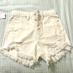 Cute High Rise Distressed Shorts. Never Worn High Waist Distressed Bottoms For Beach, White Bottoms With Frayed Hem For Beach, White Beach Bottoms With Frayed Hem, Distressed Cotton Beach Bottoms, Trendy Distressed Beach Bottoms, Ripped Cotton Bottoms For Day Out, High Rise White Bottoms With Buttons, Summer Distressed White Bottoms, Summer White Distressed Bottoms