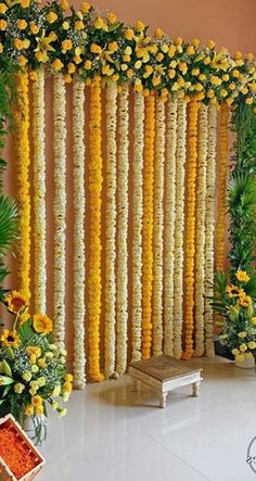 an arrangement of yellow flowers and greenery on the wall