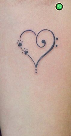 a small heart tattoo with paw prints on it