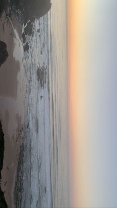 an aerial view of the beach and ocean with waves coming in from the shore line