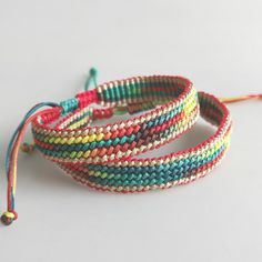 three multicolored bracelets on a white surface