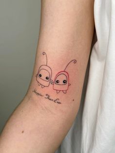 a couple of small tattoos on the arm that says happy new year and two little bugs