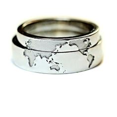 two wedding bands with the world map etched on each one in white gold and silver