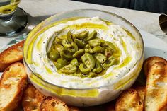 a bowl filled with cream cheese and jalapenos on top of toasted bread