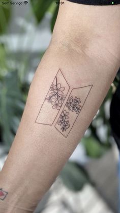 a woman's arm with a tattoo on it that has flowers in the middle