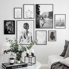 a living room with pictures on the wall and coffee table in front of couches