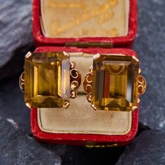 These classically-designed earrings each have an emerald cut smoky quartz stone in a four prong setting. The clean lines and neutral color make them a great choice for dressing up or dressing down. The earrings are crafted in 14k yellow gold and are finished with posts and omega backs for pierced ears. Classic Gold Earrings With Rectangular Stone, Classic Gold Rectangular Earrings, Elegant Octagon 14k Gold Earrings, Formal Octagon Gemstone Earrings, Elegant Octagon Earrings For Formal Occasions, Classic Octagon Gemstone Earrings, Elegant Octagon Gemstone Earrings, Elegant Earrings With Rectangular Stone For Anniversary, Elegant Anniversary Earrings With Rectangular Stone