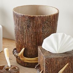 two toothbrushes and a wooden container on a table next to other items that are made out of wood