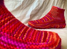 a pair of colorful knitted socks sitting on top of a bed